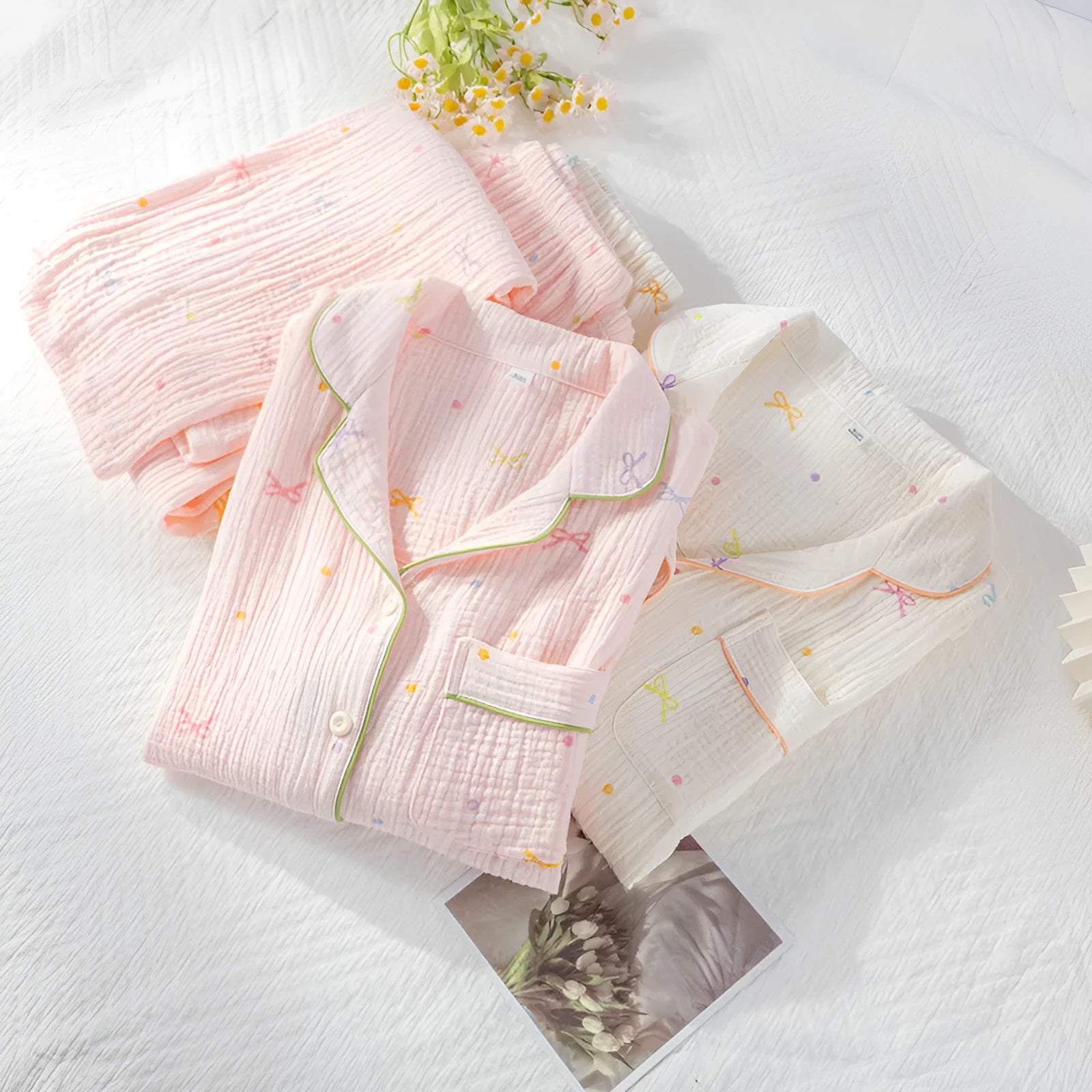 Women's thin cotton long-sleeved pajama set in pink, showing top and trousers laid flat.