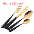 Four-piece stainless steel cutlery set with mirror-polished black finish laid out on a surface