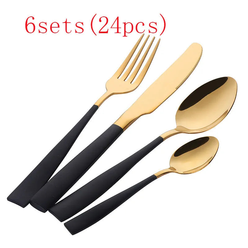 Four-piece stainless steel cutlery set with mirror-polished black finish laid out on a surface