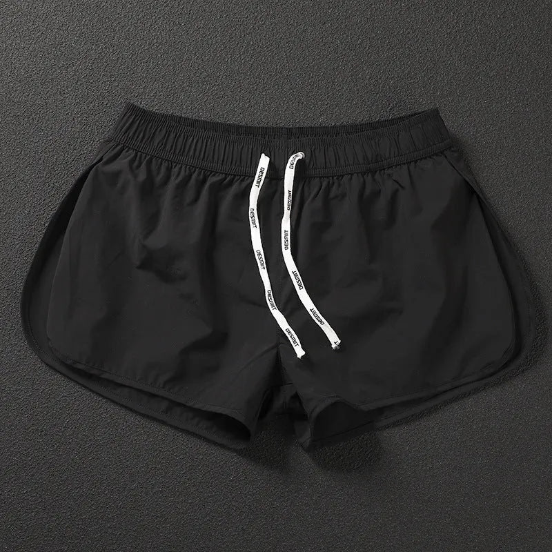 Men's loose orange beach shorts with elastic waistband on a sandy shore