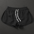 Men's loose orange beach shorts with elastic waistband on a sandy shore