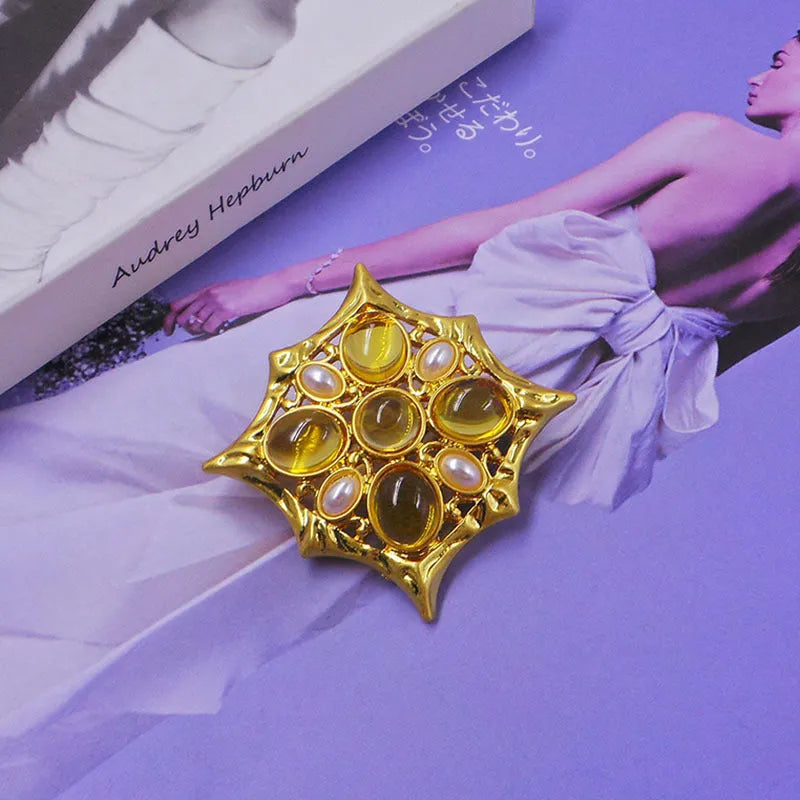 A vintage-style zinc alloy brooch with a baroque cross design and crystal accents.