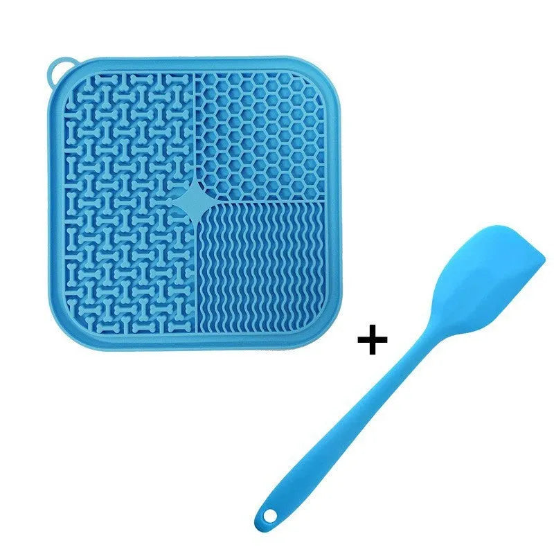 Blue silicone dog lick mat with textured surface and suction cups on back, shown on a tiled floor.