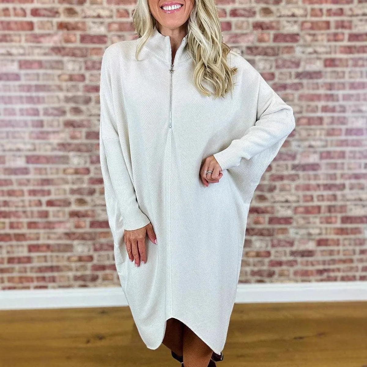 Women's solid colour loose fit knit dress with raglan sleeves on a hanger.