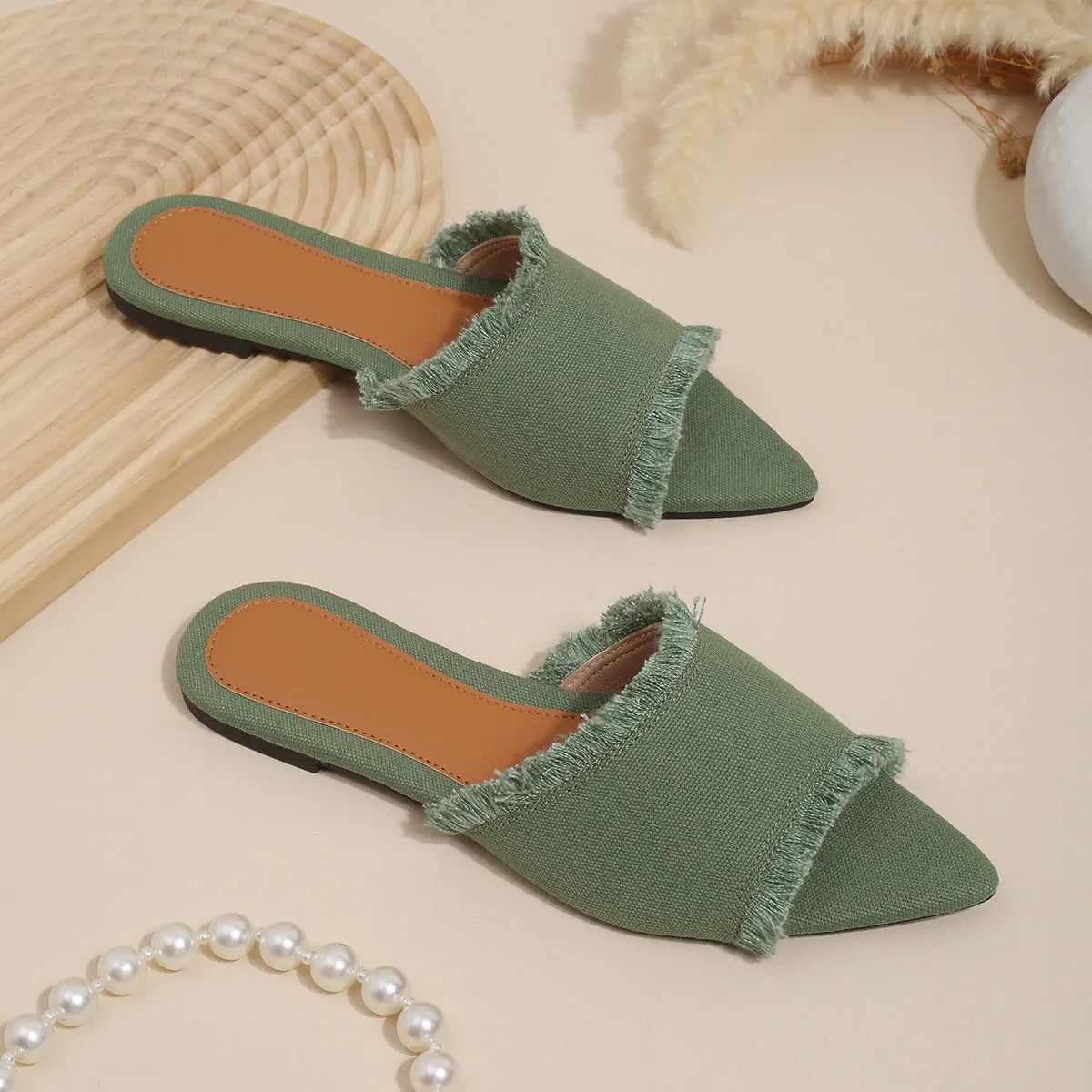 Women's flat denim slippers with tassel detail in apricot colour on a white background