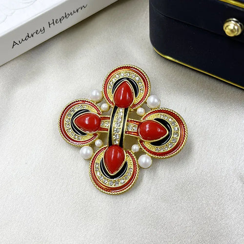 A vintage-style zinc alloy brooch with a baroque cross design and crystal accents.