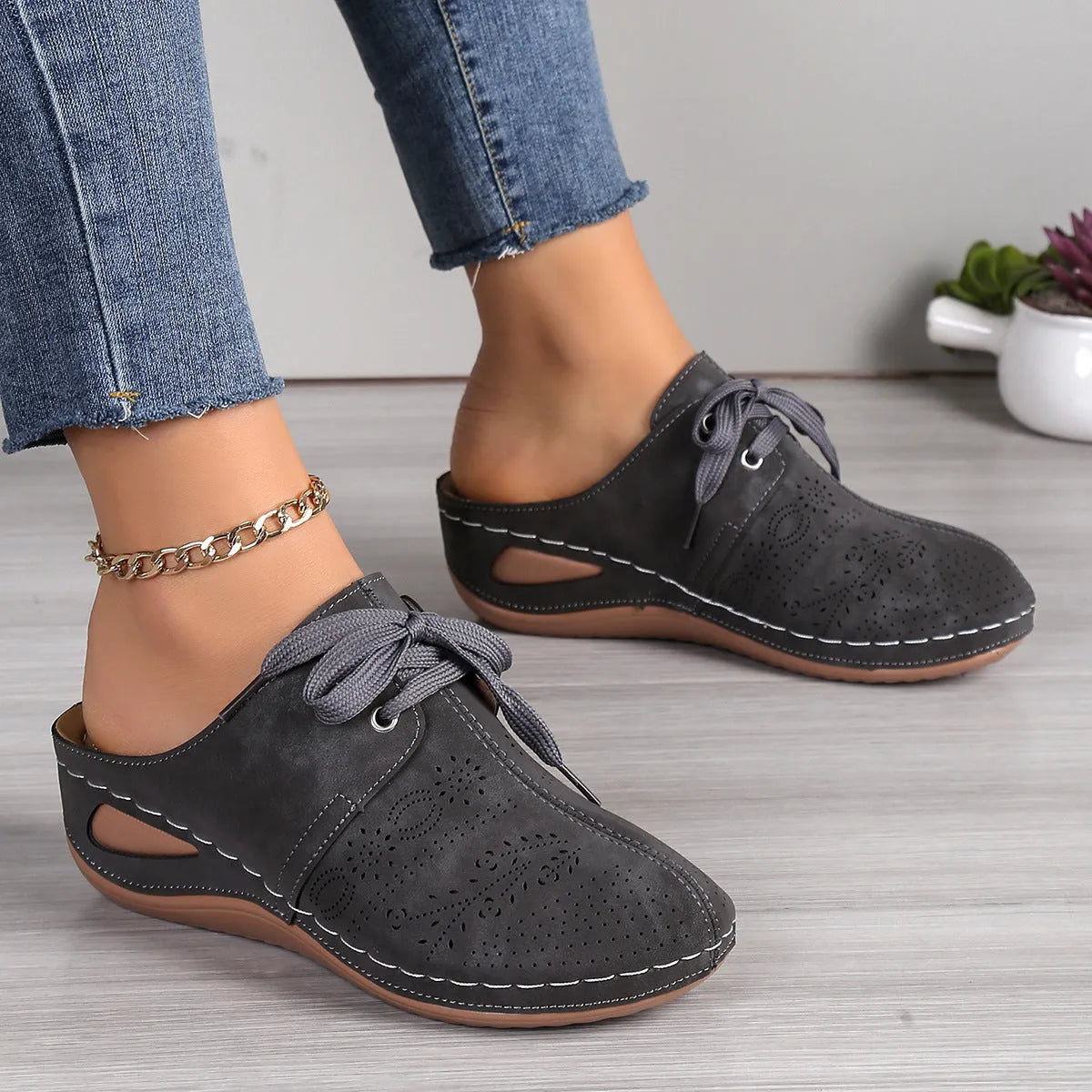 Women's black suede lace-up wedge slippers with a baotou toe and hollow out heel on a rubber sole.