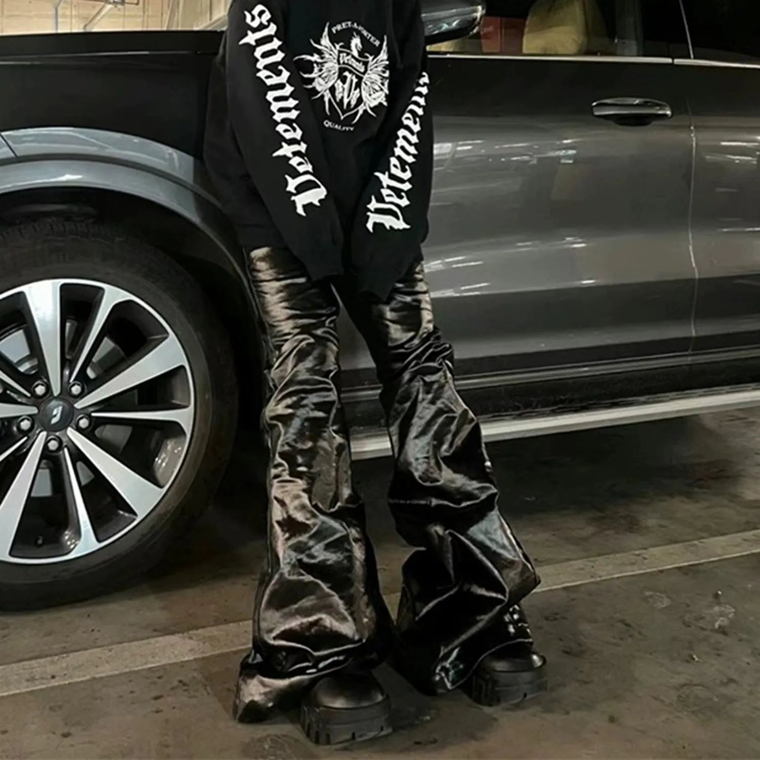Black coated patent leather skinny jeans in a straight-leg cut on a model.