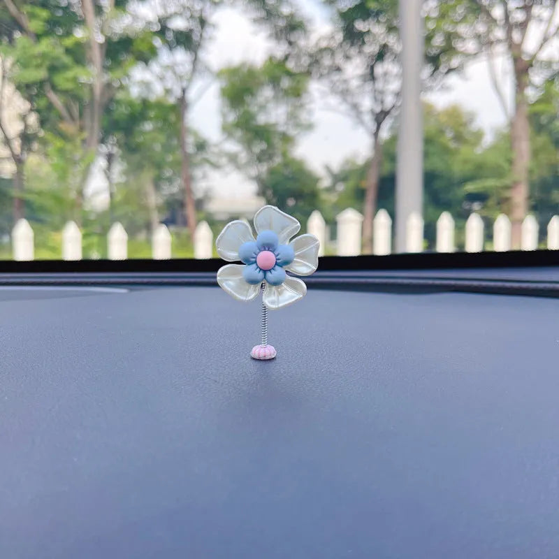 Small colourful plastic car swing decoration hanging from a rear-view mirror.