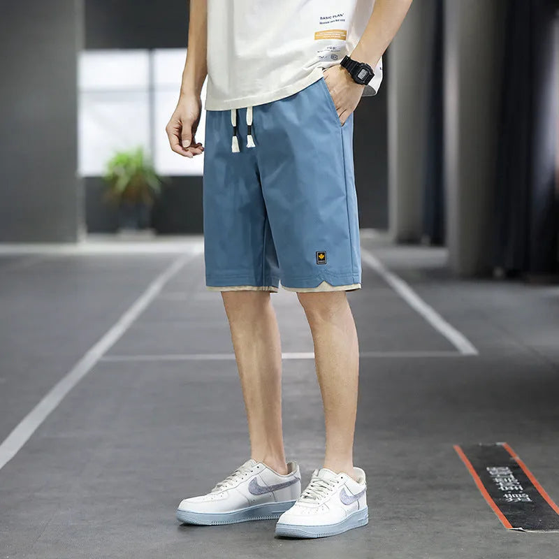 Man wearing loose-fit green casual beach shorts in a South Korea style, showing the straight cut and relaxed fit.