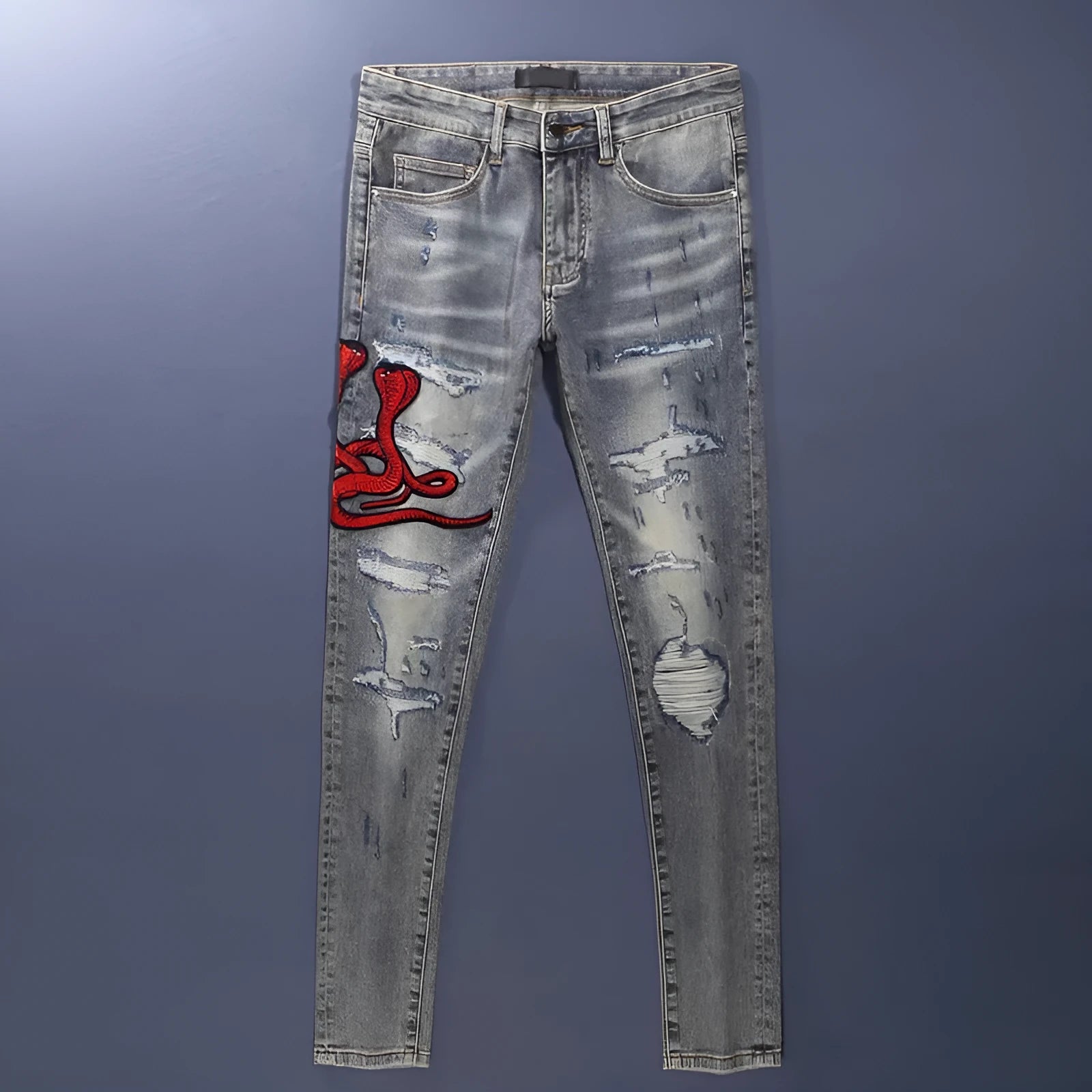Slim fit jeans with a washed-out old colour finish, hole patches, and embroidery detail on the legs.