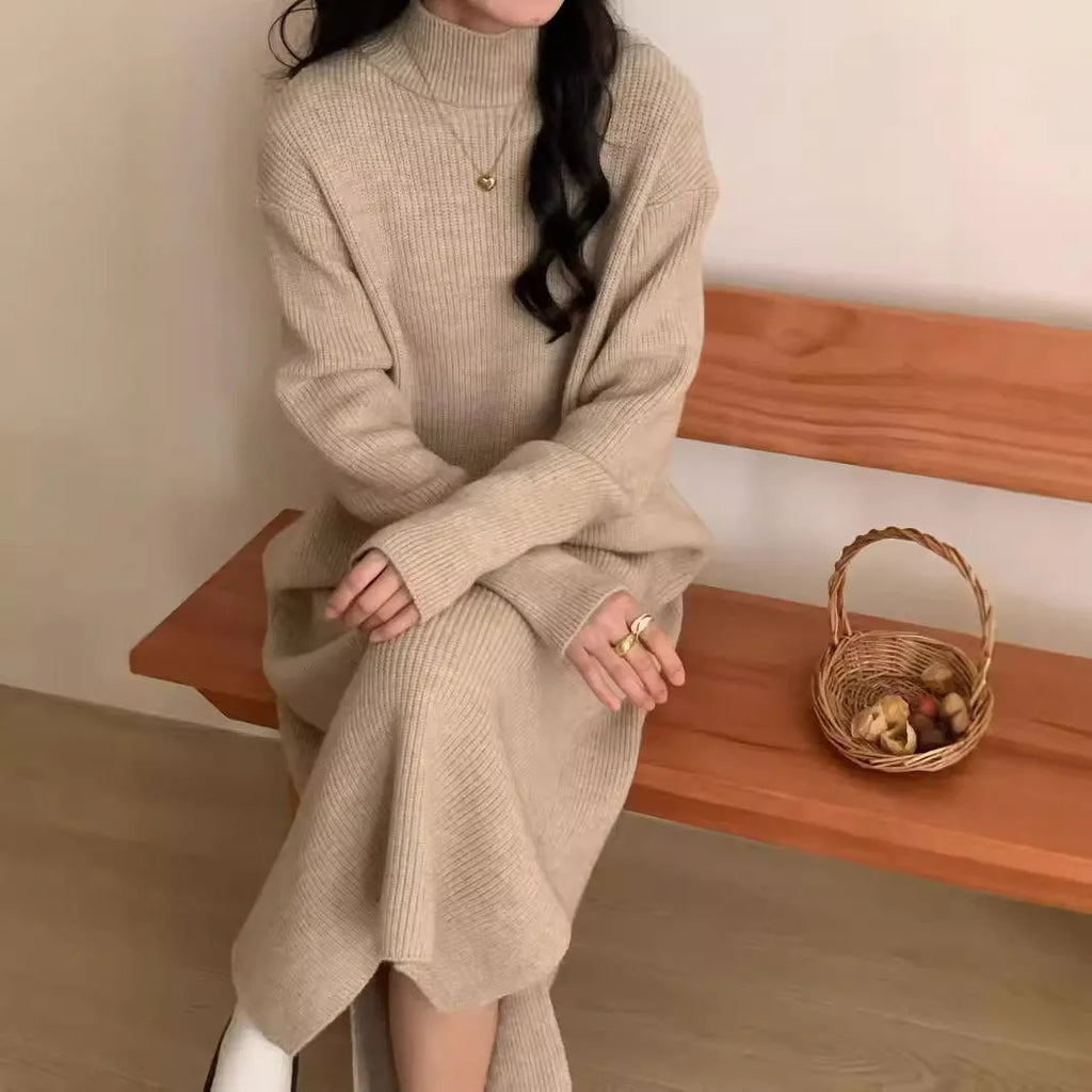 Woman wearing a beige high-waist knitted midi dress with long sleeves and a half turtleneck neckline.