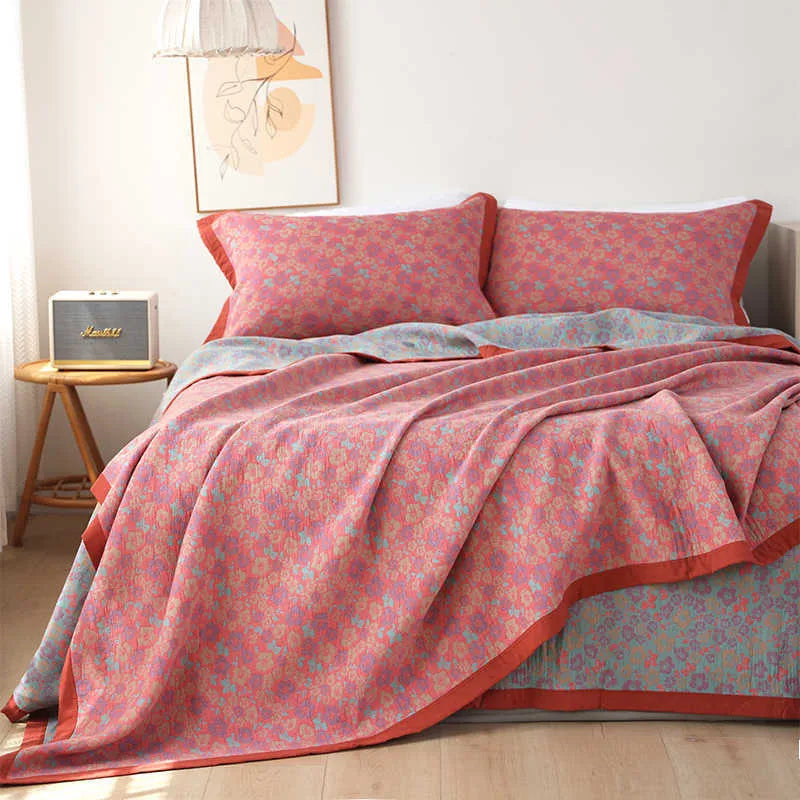 Three-piece cotton gauze bed blanket set with floral botanical pattern, shown with pillowcases.