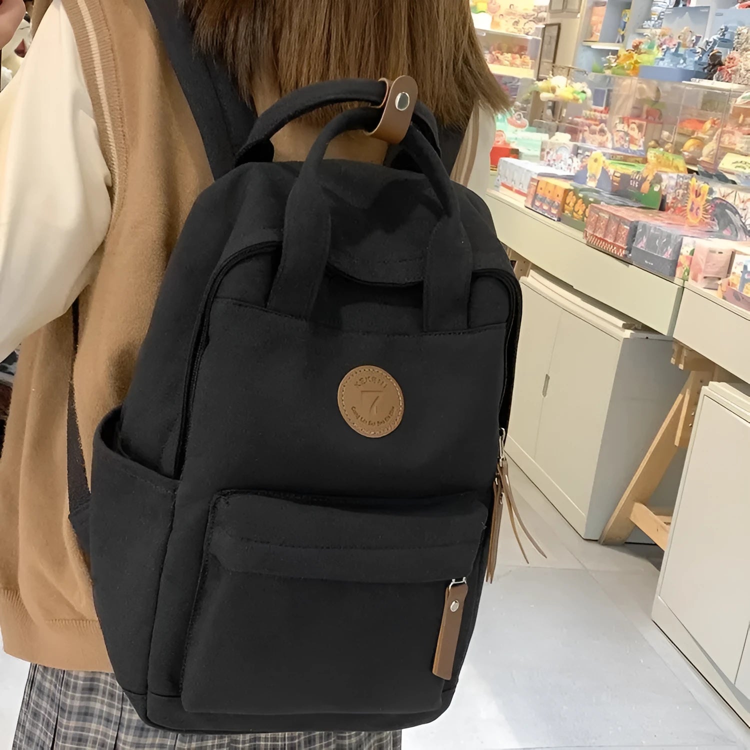 Black Oxford cloth fashion backpack with curved shoulder straps showing retro sewing thread details