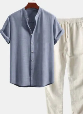 Man wearing a loose-fit light-coloured linen short-sleeve shirt and matching casual trousers from a two-piece suit set.