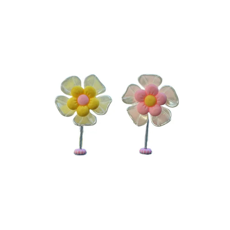 Small colourful plastic car swing decoration hanging from a rear-view mirror.