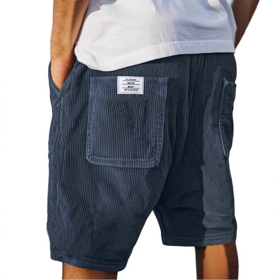 Men's grey corduroy shorts with multiple pockets and embroidery detail on leg, laid flat.