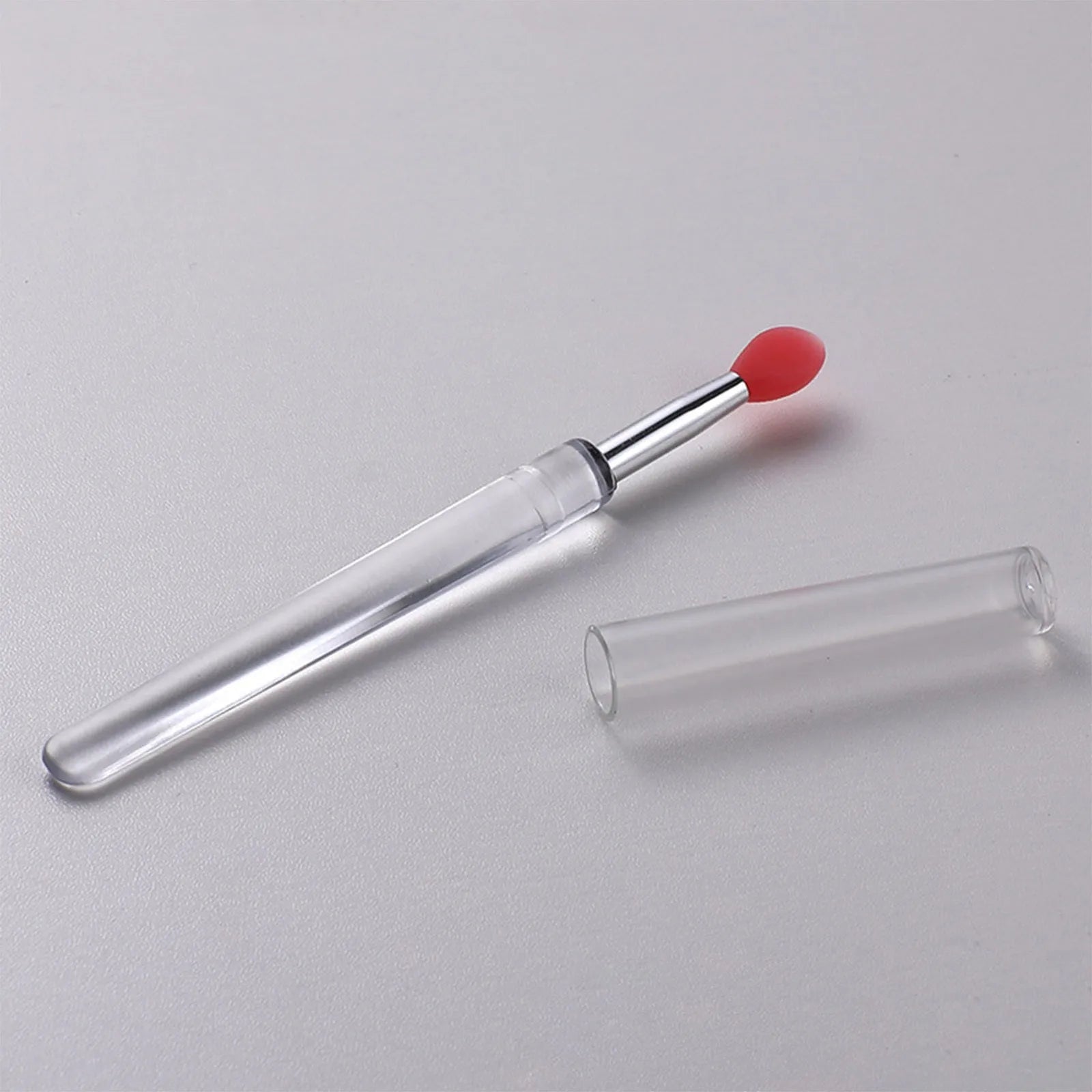 Set of coloured silicone lip brushes with protective caps for applying lipstick and lip gloss.
