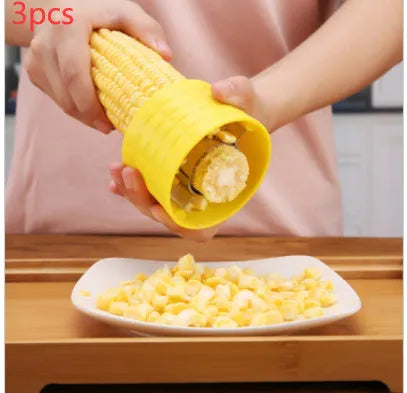 Yellow manual corn grinder thresher with a corn-kernel shaped PP handle and stainless steel peeling gear.