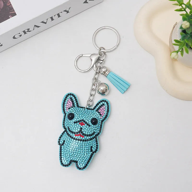 Close-up of a cartoon dog rhinestone keychain charm in alloy, showing sparkling details on a grey background.