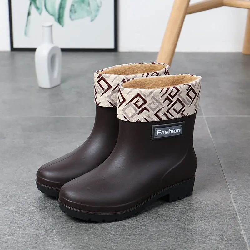 Women's mid-calf PVC rain boot in black on a wet surface.