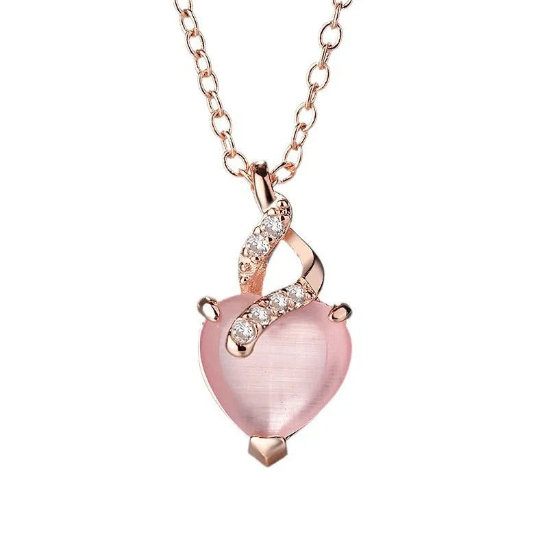 Rose gold cross chain necklace with a pink heart-shaped synthetic crystal pendant.