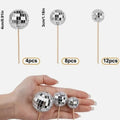 Silver reflective glass disco ball cake topper on a wooden stick for birthday party decoration.