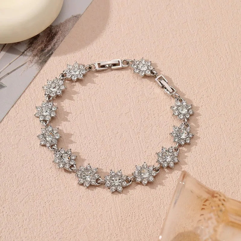 A gold or silver electroplated zinc alloy flower bracelet with coloured gems.