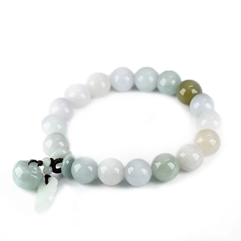 Natural green jade bracelet with a geometric pendant charm on a wrist.