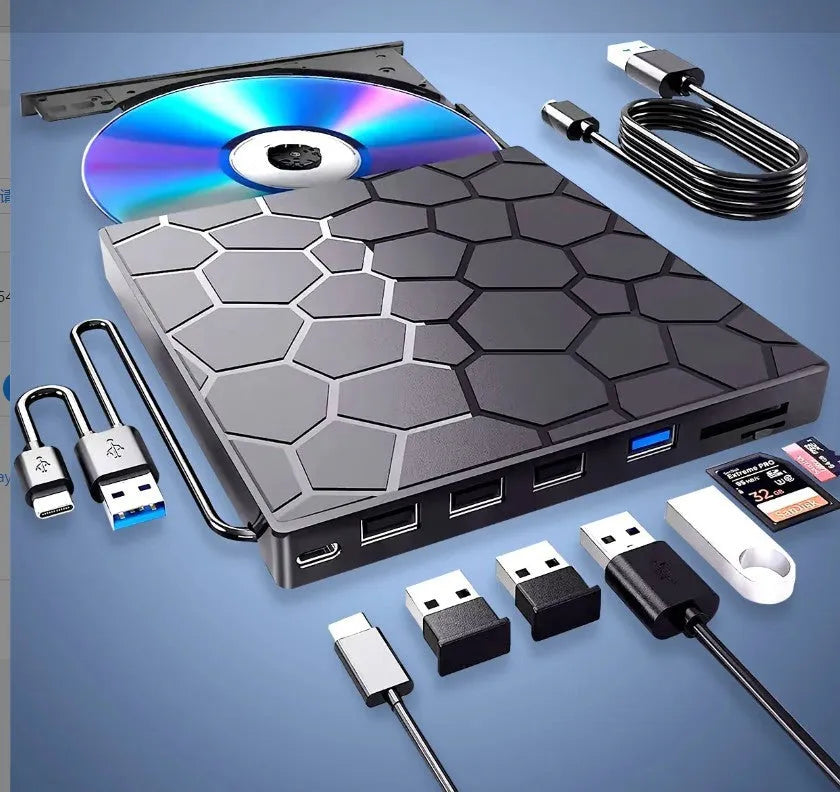 Black external USB CD/DVD writer and reader drive on a desk next to a laptop.