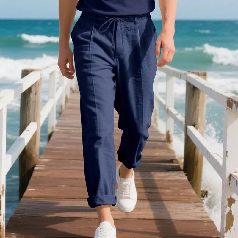 Men's loose-fit straight-leg linen trousers in light khaki colour with a drawstring waist.