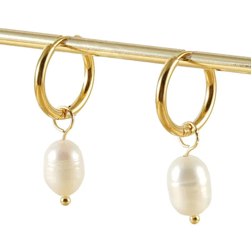 A pair of gold geometric earrings with a pearl detail on a stainless steel post.