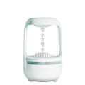 Black or white anti-gravity humidifier with water droplet effect on a desk.