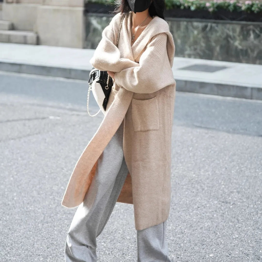 Long grey knitted hooded cardigan trench coat on a hanger showing its 80cm length and thick texture.