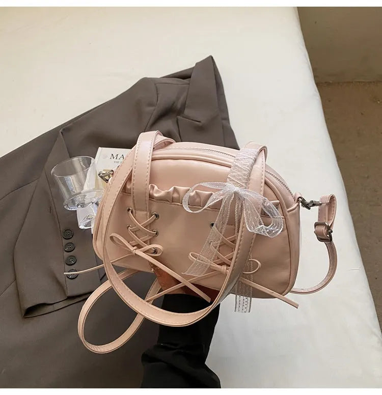 Milky white women's PU shoulder bag with a black bandage bow and sewing thread detail.