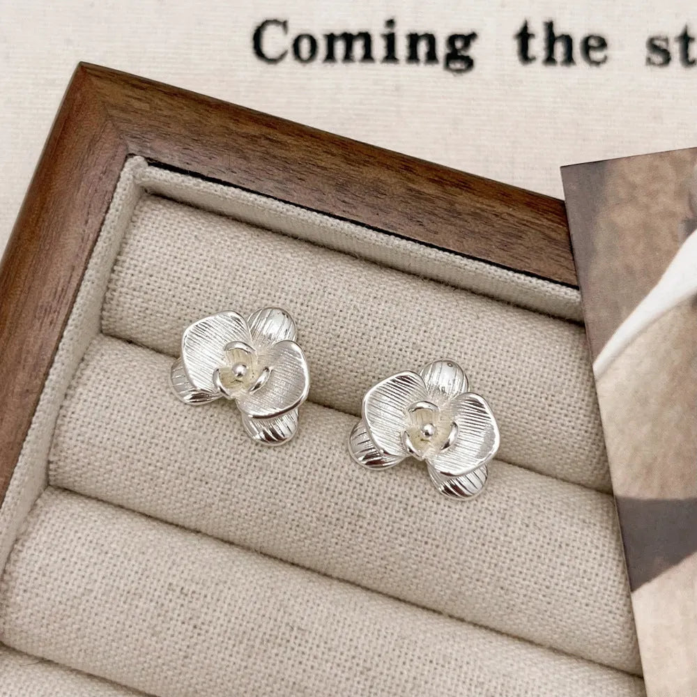 A pair of retro-style copper flower earrings with petal details in a gold electroplated finish.