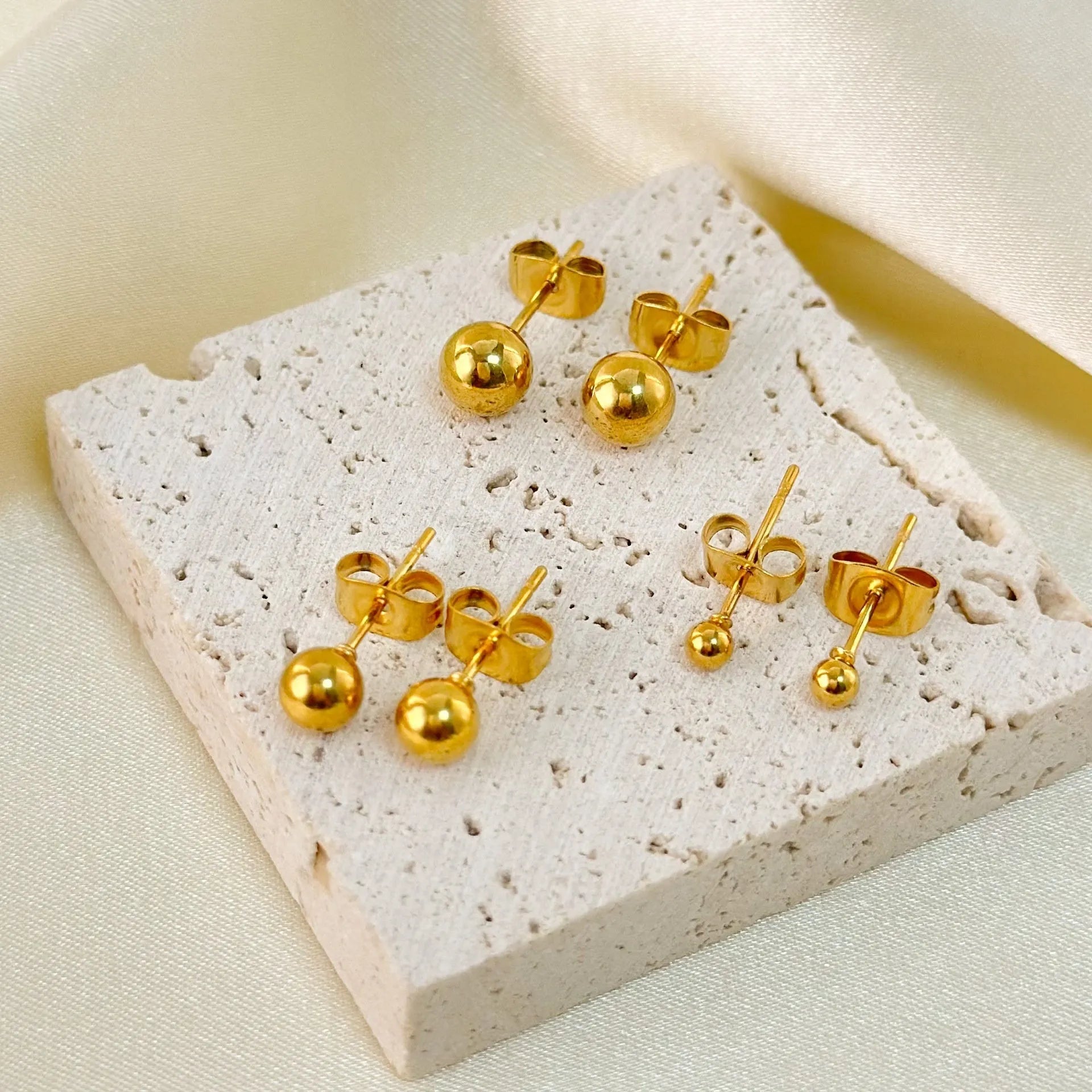 Minimalist stainless steel ball stud earrings in gold and silver tones, showing 3mm 4mm 5mm 6mm size difference.