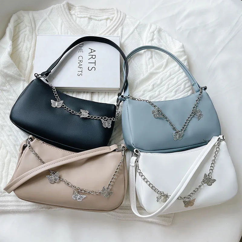 Retro-style square crossbody handbag with a butterfly clasp on its chain strap.
