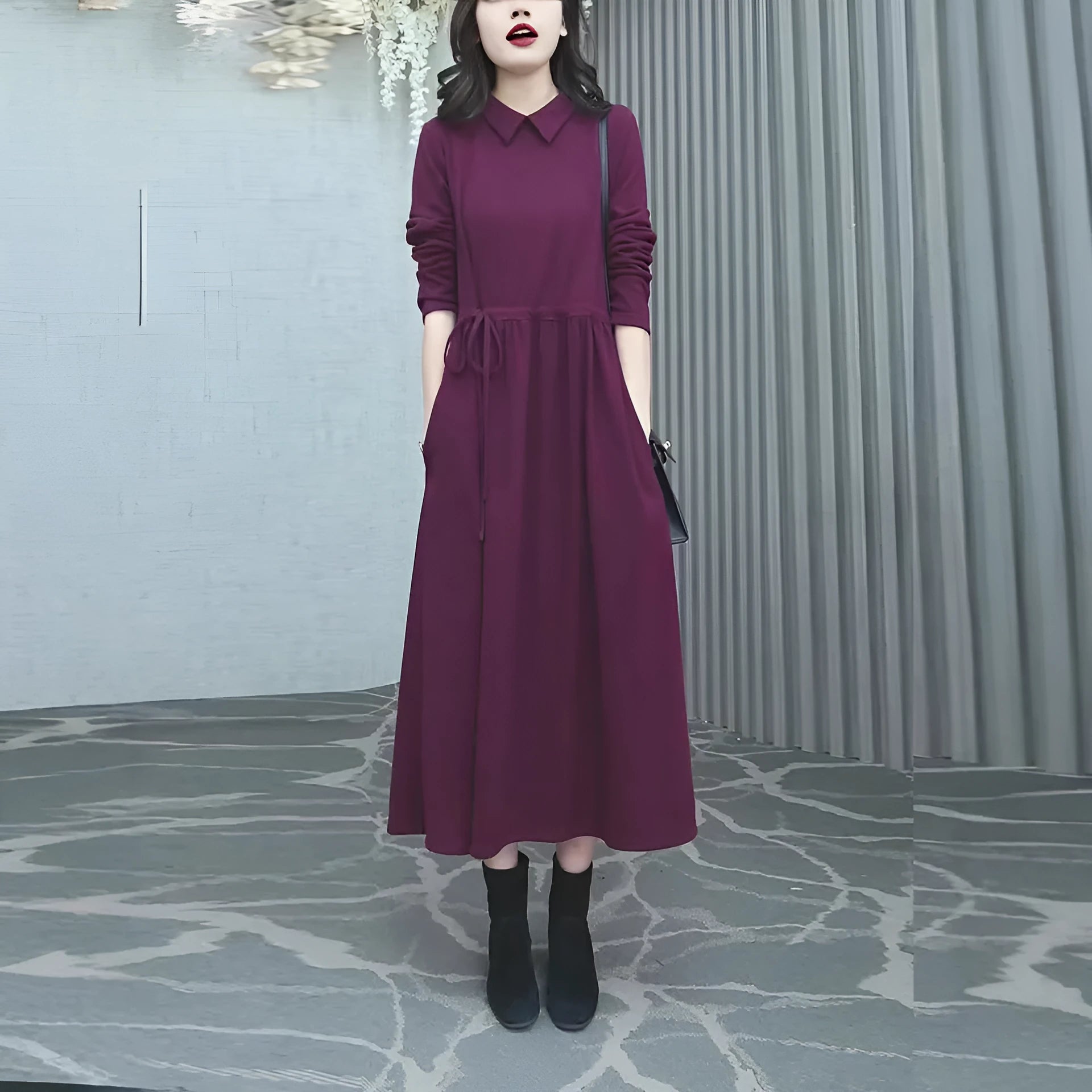 Purplish red plus size women's dress with long skirt and extra-long sleeves on a model.
