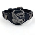 Black geometric leather bracelet with a detailed eagle watch-button clasp, shown flat.