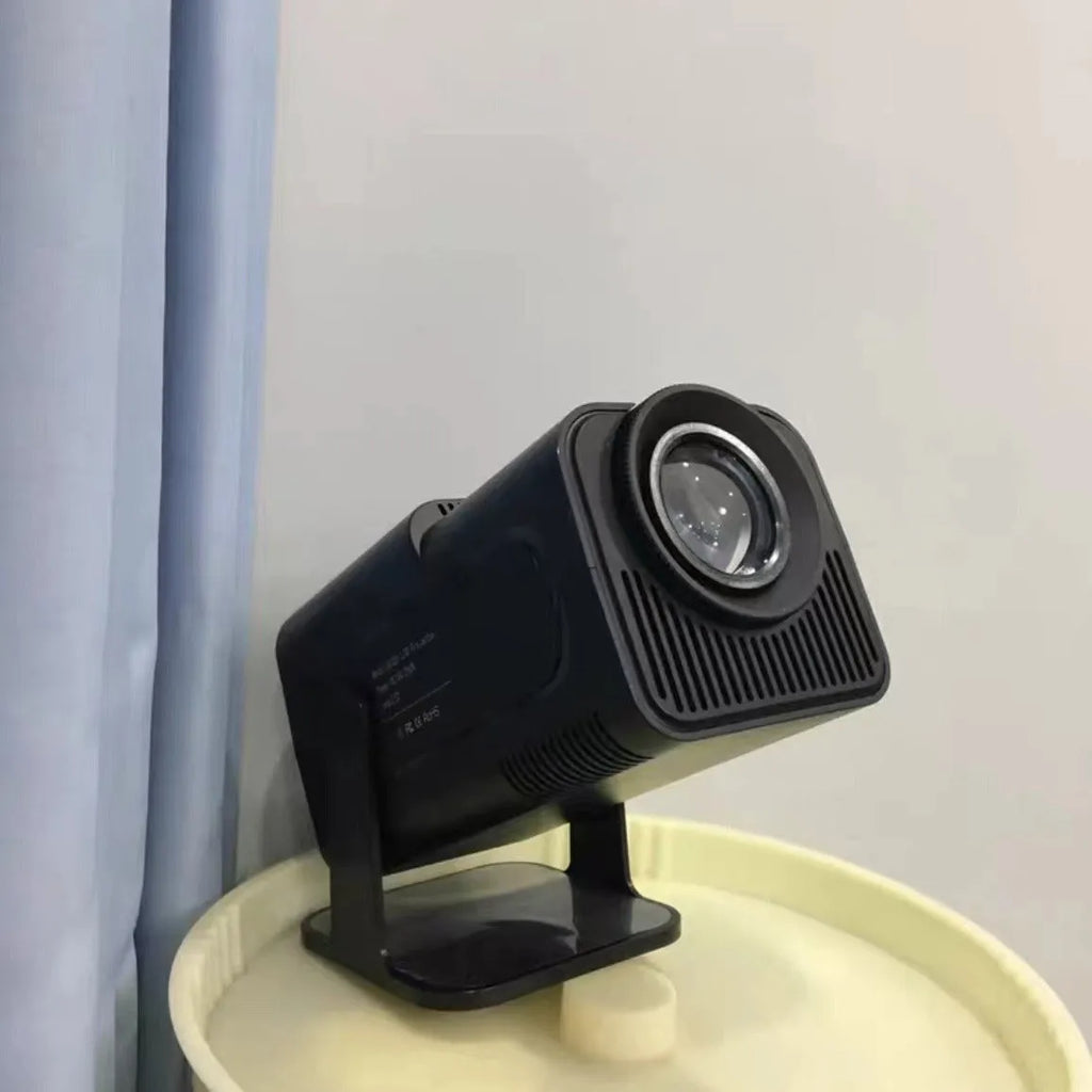 A white HD wireless game projector for home use on a wooden surface.