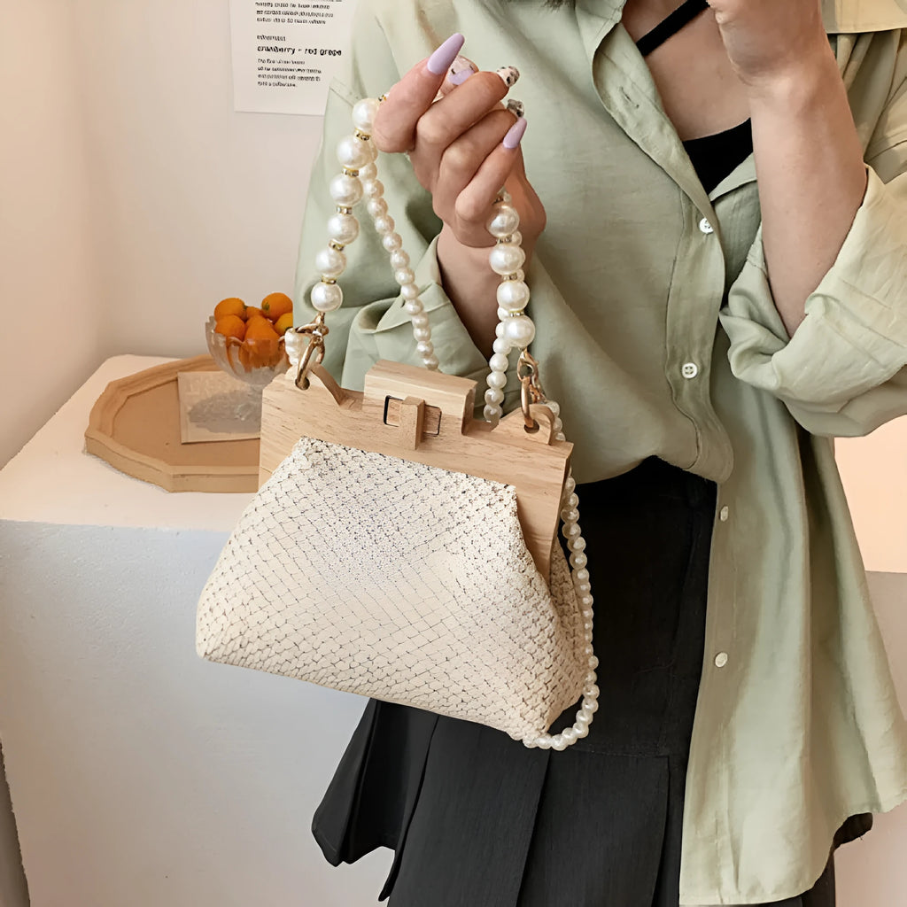 Women's straw woven shoulder bag with pearl chain detail showing internal organisation compartments
