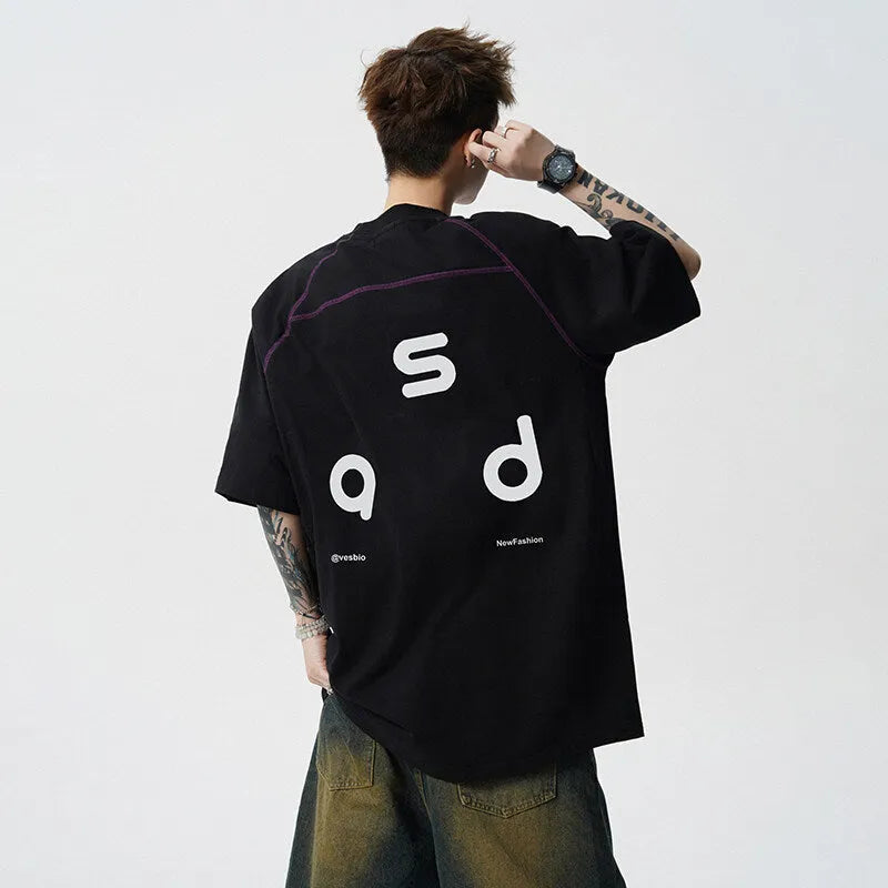 Man wearing a black loose-fit cotton T-shirt with a letter print on the chest.