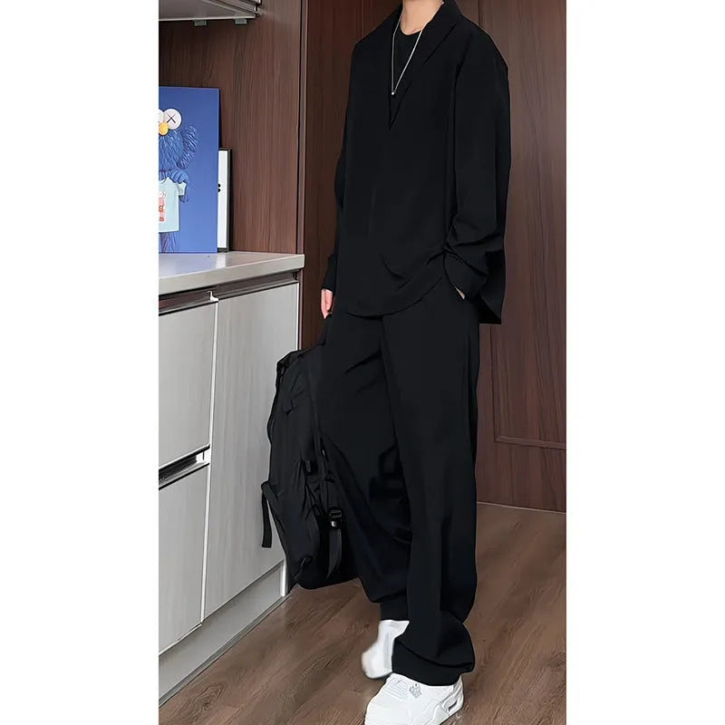Men's black slim fit two-piece casual suit with long sleeve polo shirt and trousers on a hanger.