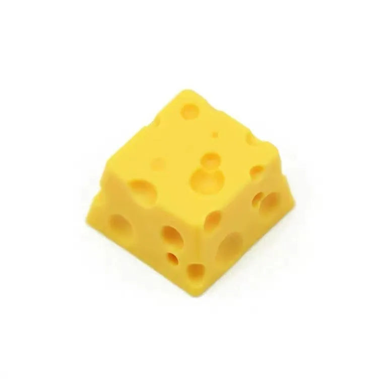 Yellow resin mechanical keyboard keycap shaped like a cheese wedge with a cute character face.