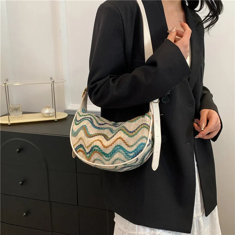 Knitted straw woven crossbody bag showing woven texture and internal organisation pockets