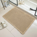 Square checkered-pattern non-slip bathroom carpet in a neutral colour on tiled floor.