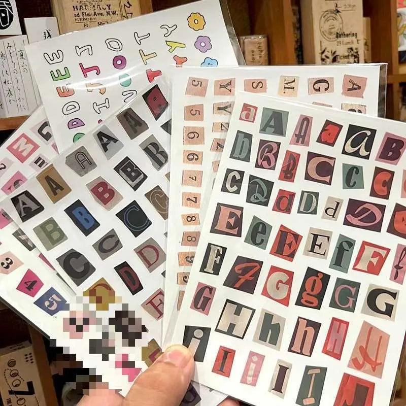 Decorative sticker sets showing English letters, numbers, and week words in colourful printed designs for crafting and labelling