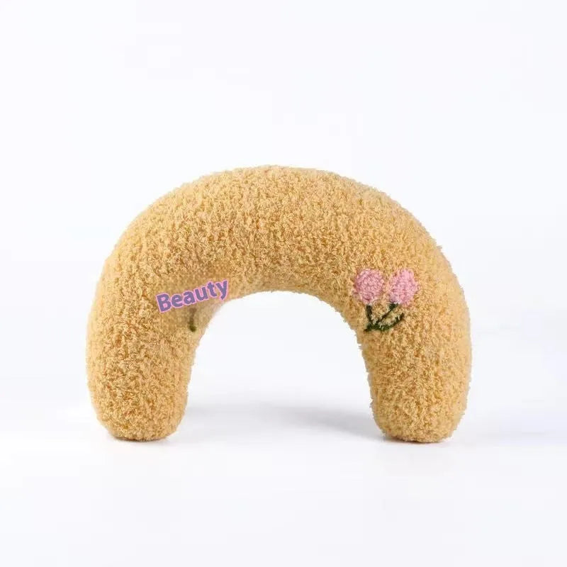 Blue question mark shaped cloth pillow for cat neck support on a pet sleeping mat