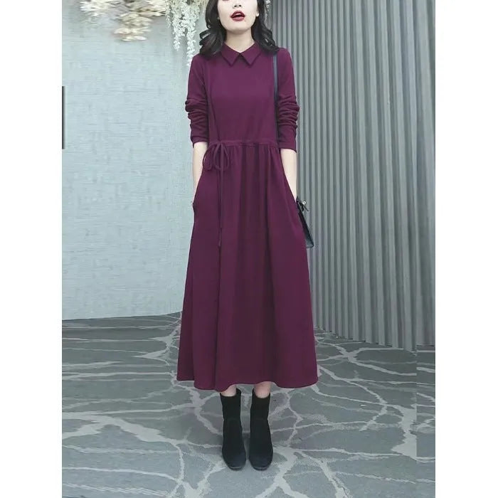 Purplish red plus size women's dress with long skirt and extra-long sleeves on a model.